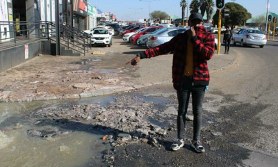 Coat corner’s manager Lawrence Magabane poiting out the sewerage leakage at the front of their shop.