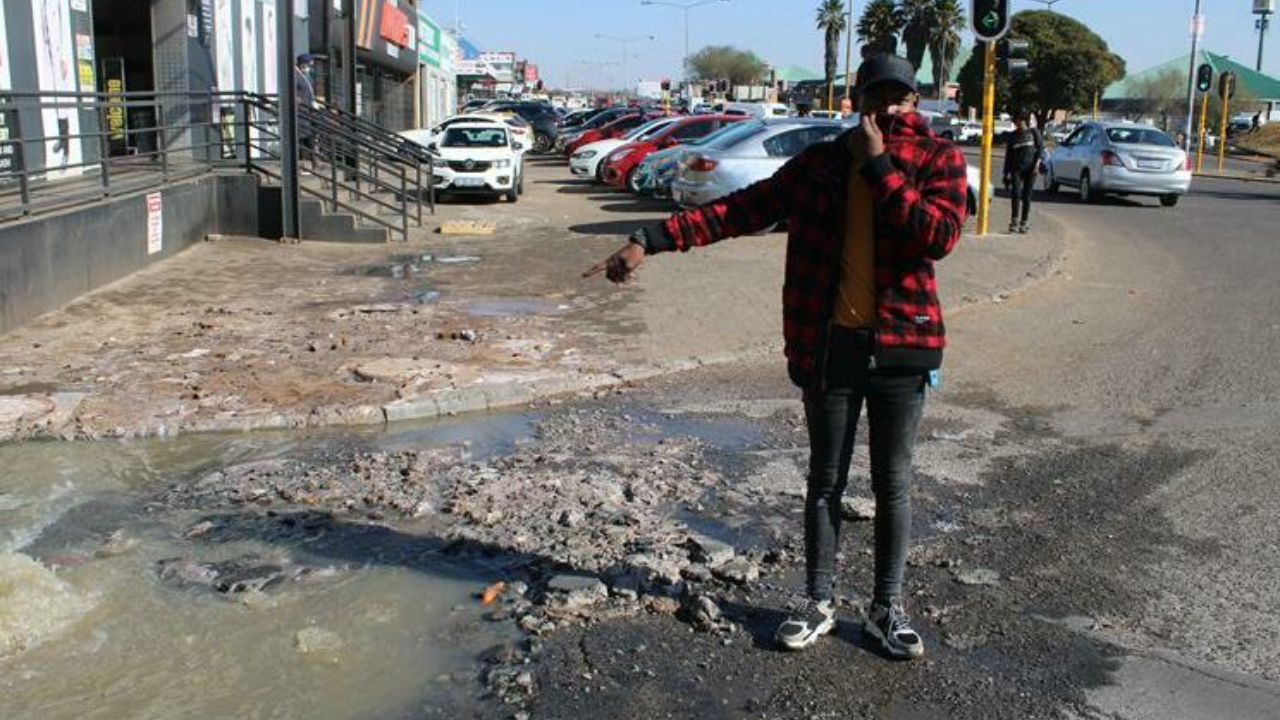 Coat corner’s manager Lawrence Magabane poiting out the sewerage leakage at the front of their shop.