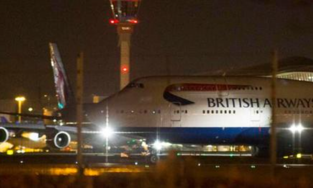 An aircraft taxis next to the control tower at Heathrow airport in London