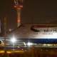 An aircraft taxis next to the control tower at Heathrow airport in London