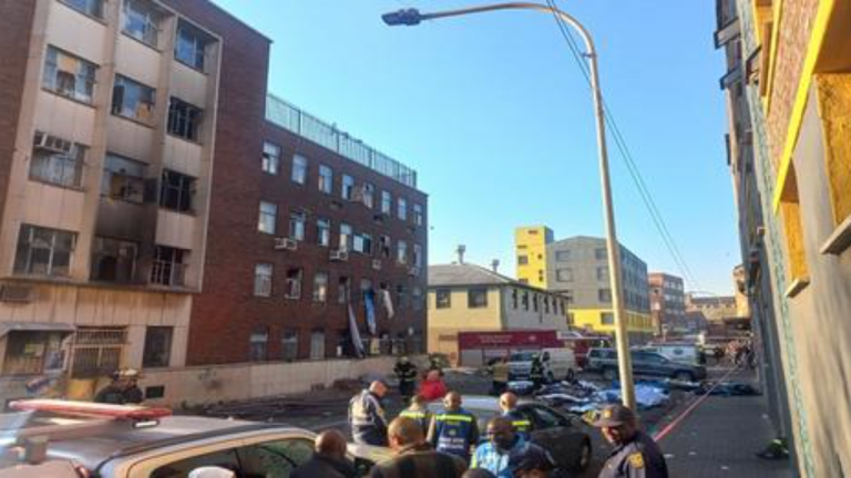 EMS personnel and police are seen on site in a building in Johannesburg that caught fire in the early hours of the morning in this image captured on 31 August 2023.